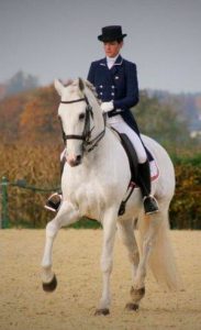 Photo de Fanny Lerpinière et son cheval blanc lors de leur passage au concours de dressage